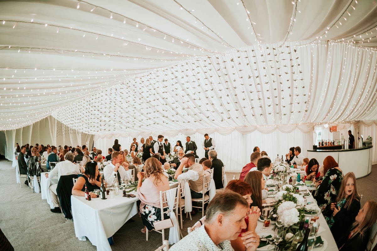 Guests dining in a clear span wedding marquee | County Marquees East Anglia