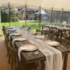 Decorated reclaimed wood trestle tables in a clear span marquee