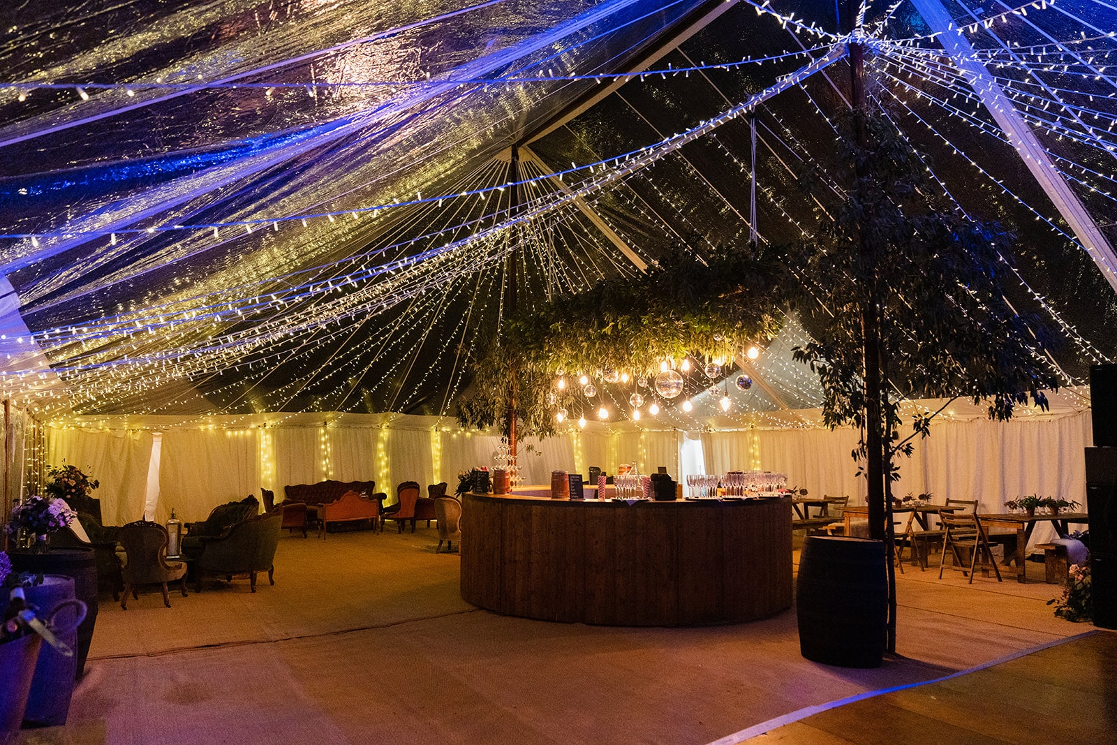 Guests enjoying a warm and cozy marquee hire for winter party during snowfall