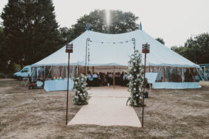 A stunning white marquee set up on the lawn of a countryside manor, perfect for couples hiring a marquee for a wedding in a romantic outdoor setting.